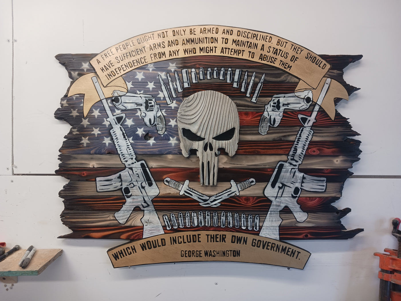 A wooden sign adorned with a Punisher skull and crossed guns, representing a fierce and rebellious spirit in its design